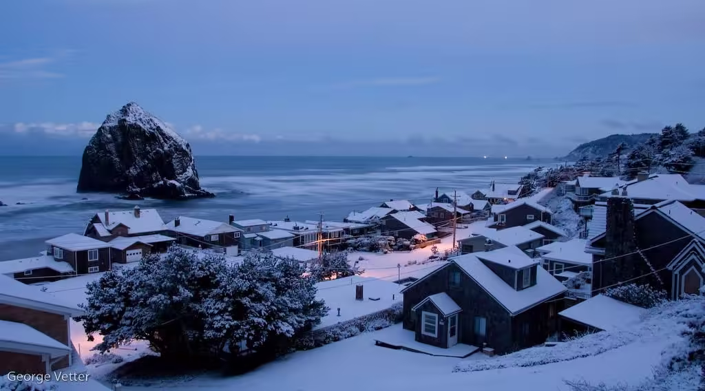 Cannon Beach Snow-dusted coastal town overlooking the ocean with Haystack Rock visible offshore at twilight